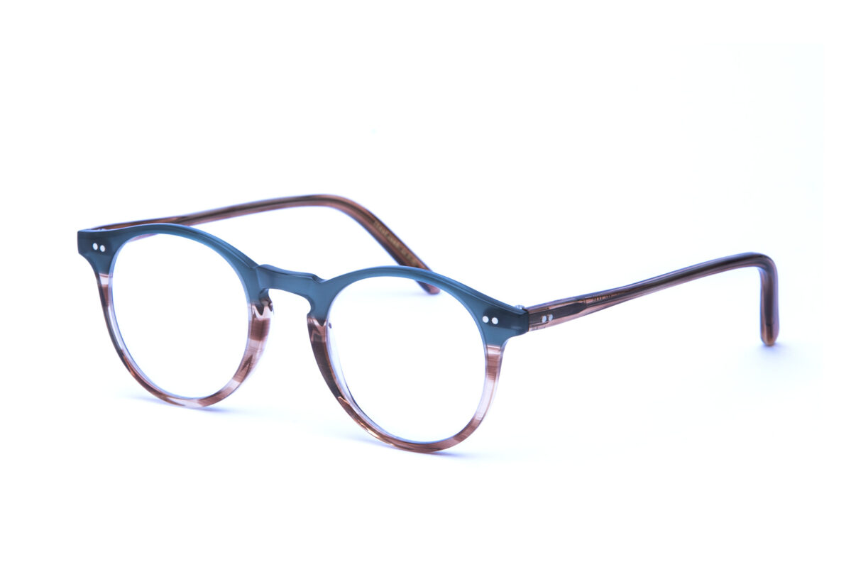 Adamo è un occhiale da vista in acetato bicolore, con una forma tondeggiante e un ponte a forma di buco della serratura realizzata con maestria artigianale