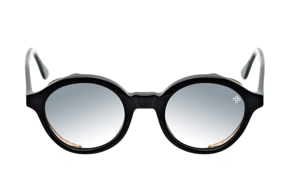 M008 di David Marc è un occhiale da sole rotondo in acetato, impreziosito da una raffinata trama a rete in metallo intorno alle lenti.