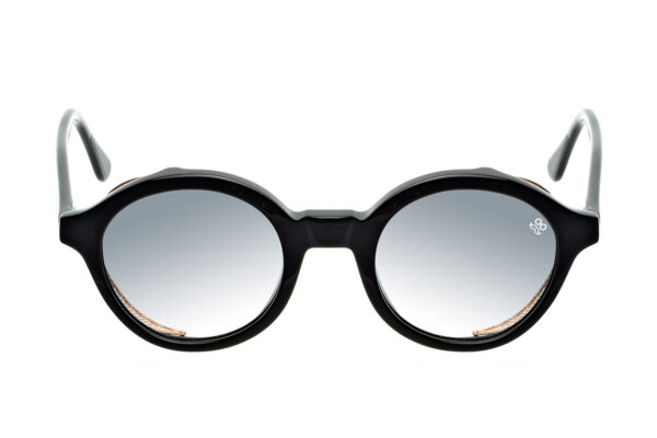 M008 di David Marc è un occhiale da sole rotondo in acetato, impreziosito da una raffinata trama a rete in metallo intorno alle lenti.